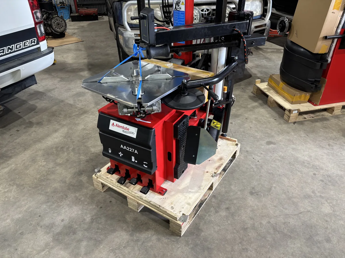 A red tyre changer on its pallet in the workshop.