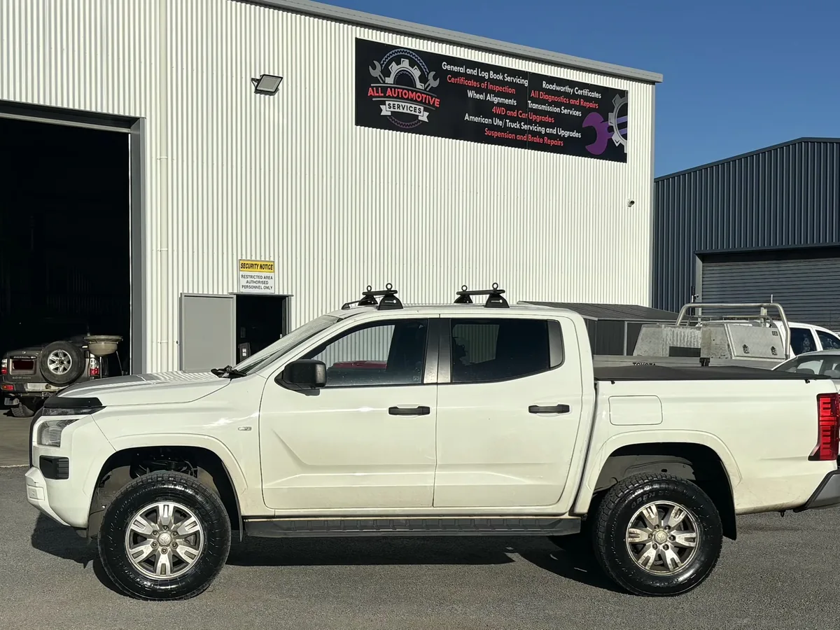 A white ute parked in front of the workshop.